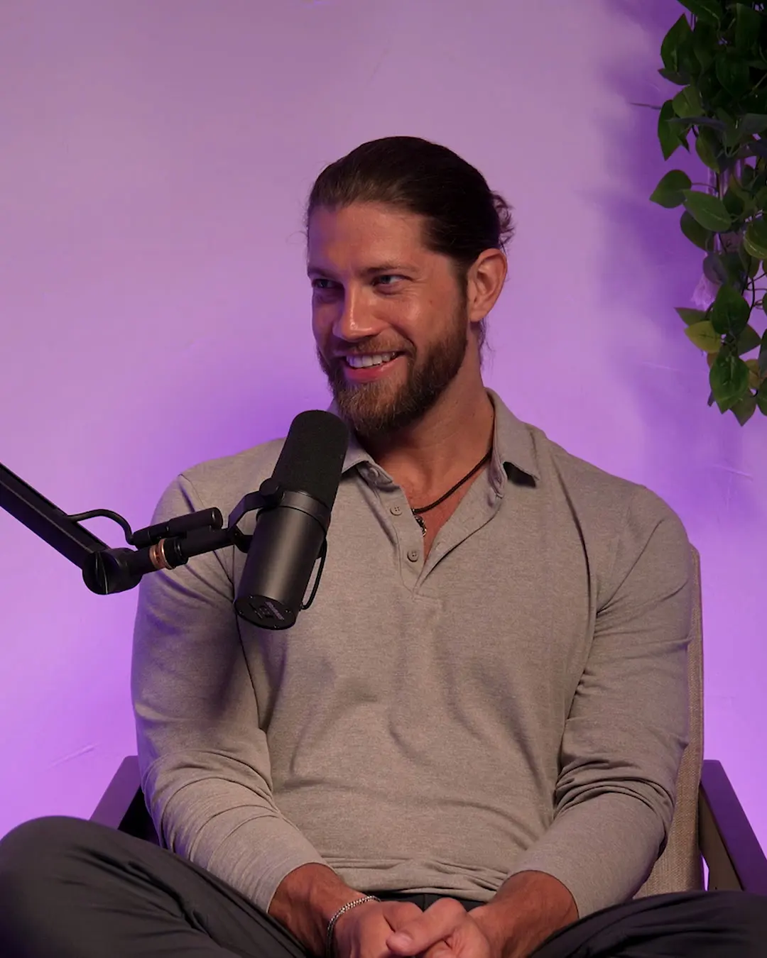 Kevin Cox, bearded, smiling in a podcast studio, in a grey shirt beside a microphone.